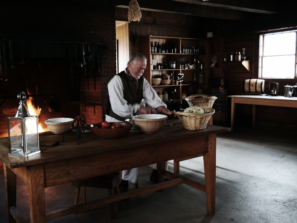 Volunteer dressed in period clothing in the reconstructed fort's kitchen. Volunteer dressed in period clothing in the reconstructed fort's kitchen.