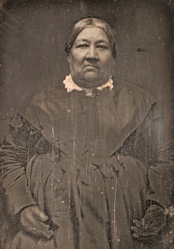A black and white photo of an older woman in a dark dress.