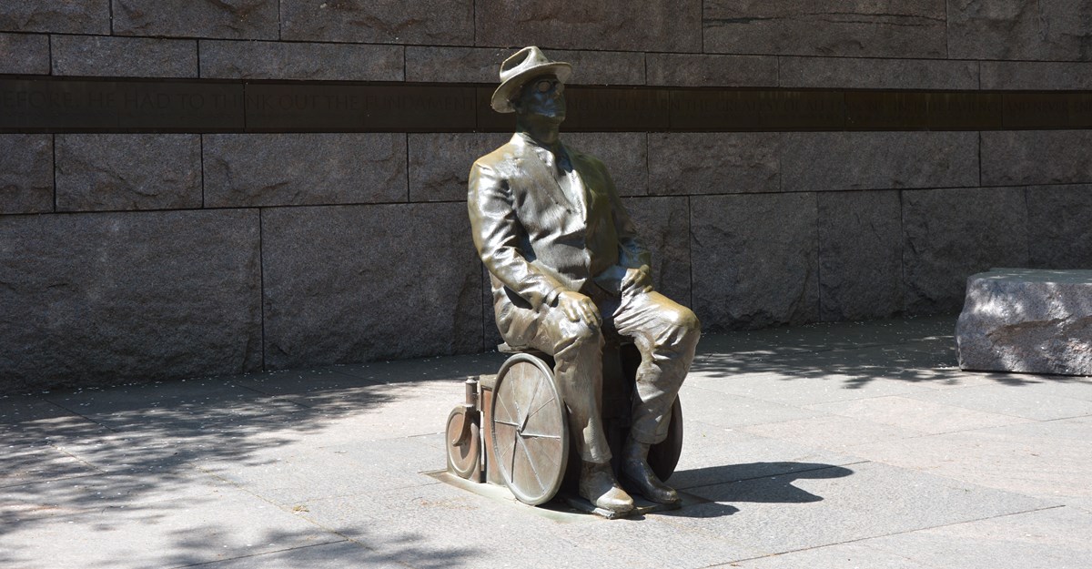 Bronze statue of Franklin Roosevelt in a wheelchair at the entrance of the FDR Memorial