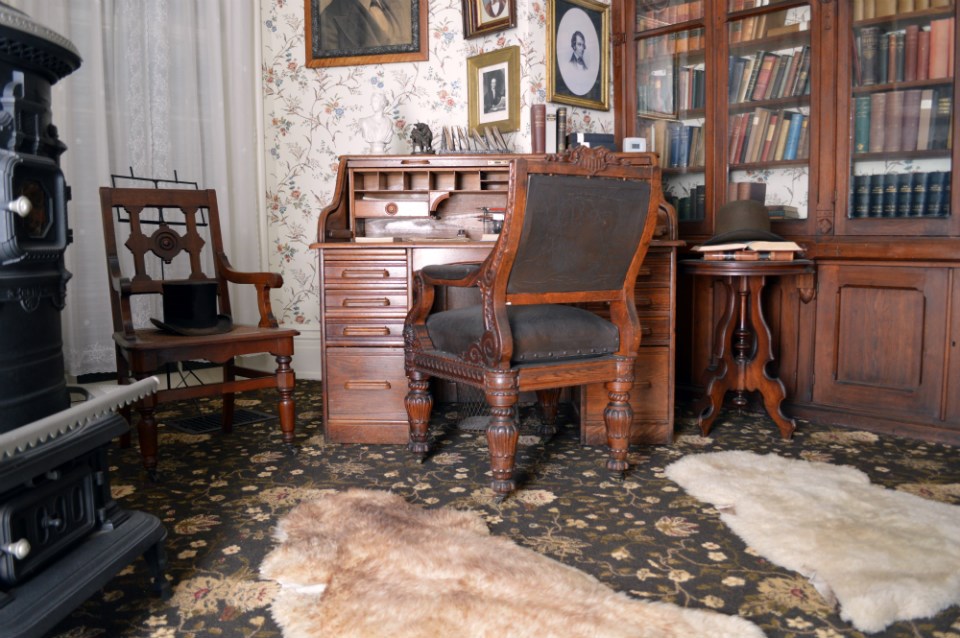 An office with a desk, chairs, and bookshelves