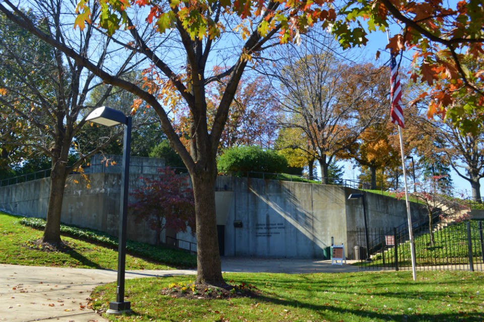 A concrete building surrounded by trees with fall foliage