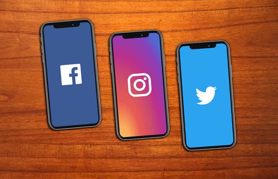 Three cell phones with social media logos on their screens