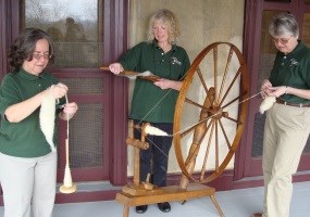 Volunteers spinning and carding wool