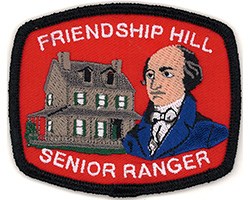 Red patch with black border.  The words "Friendship Hill Senior Ranger" are embroidered above and below the embroidered images of the Stone house and bust of Albert Gallatin