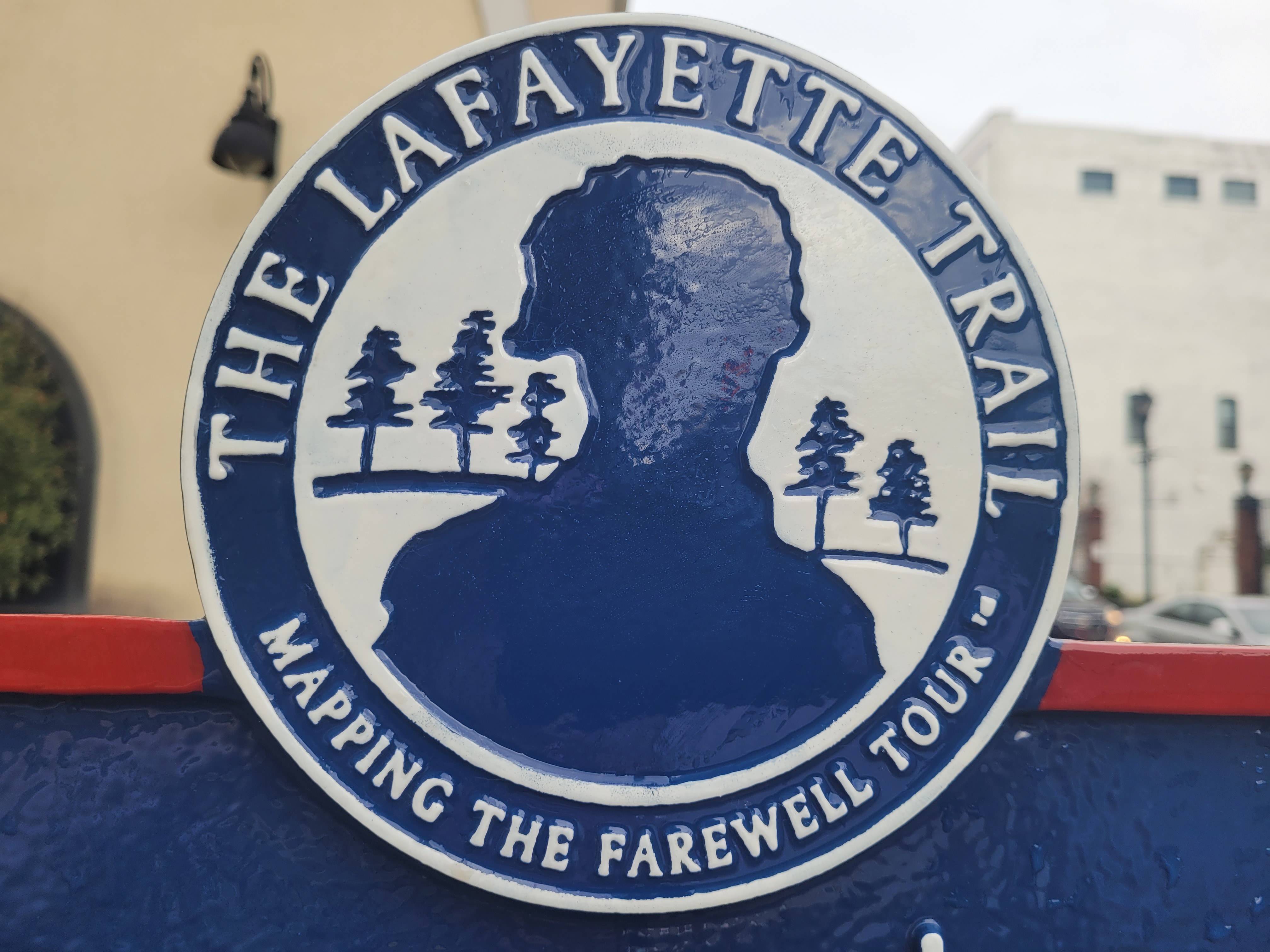 The Lafayette Trail Mapping the Farewell Tour A white circle with blue text and a man's silhouette with a line of trees behind him
