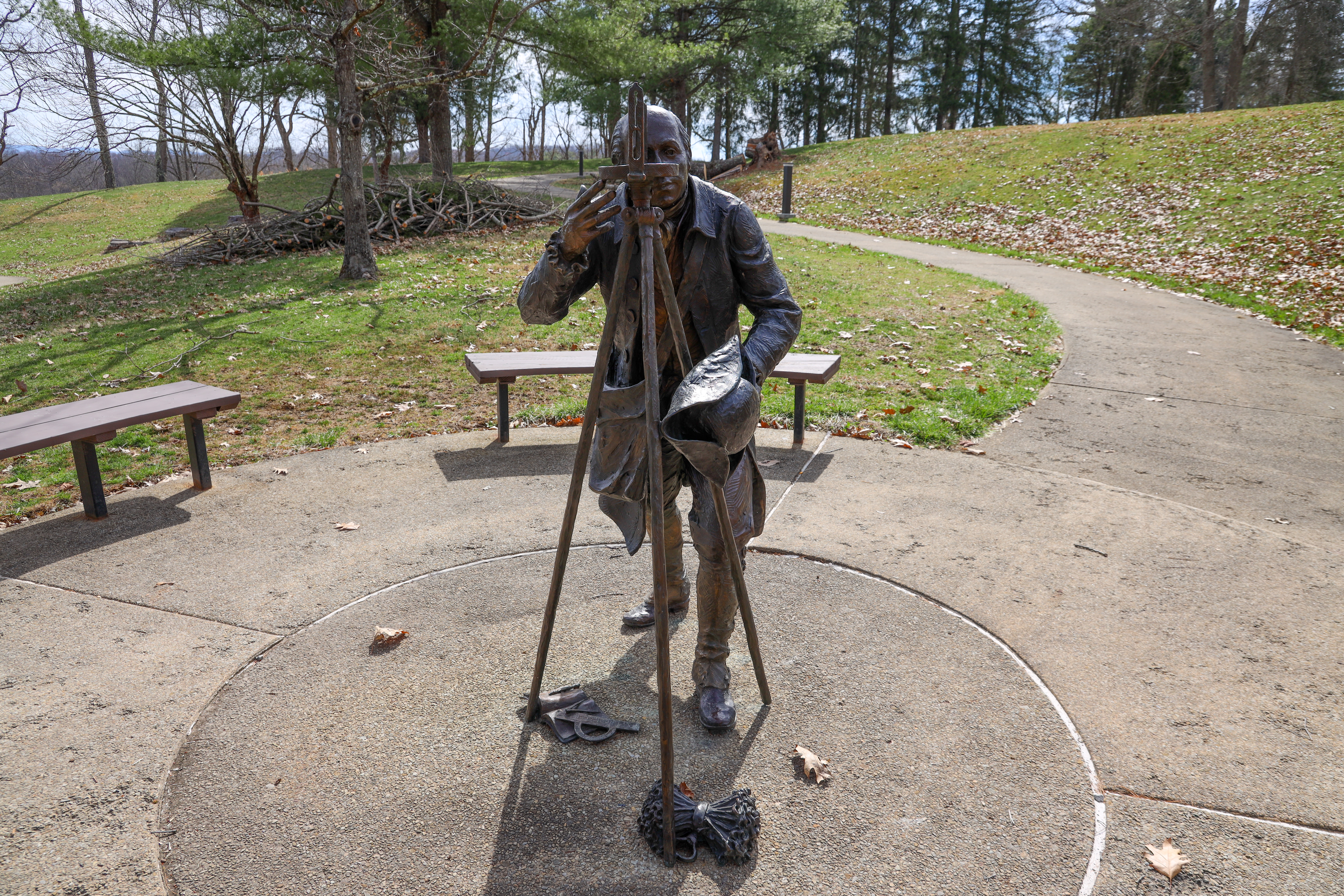 Albert Gallatin sculpture cemented to accessible concrete walking path.