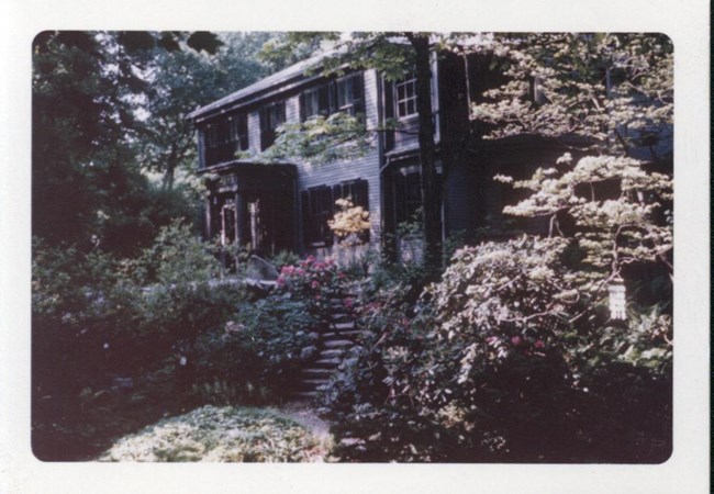 Red house framed by colorful flowers in bloom