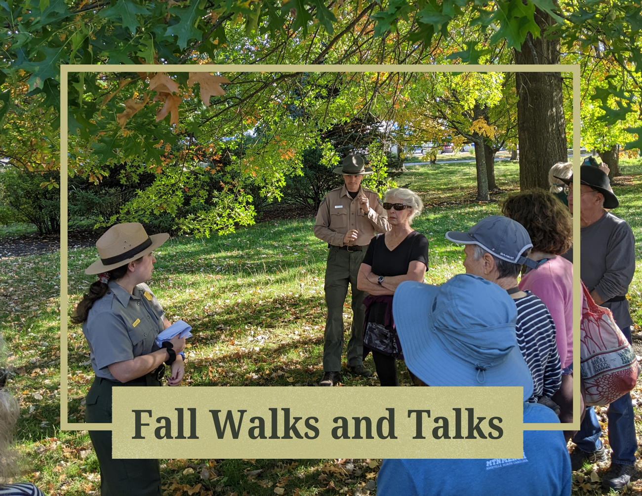 group of people standing around as a park ranger gestures with a yellow border entitled "Fall Walks and Talks"