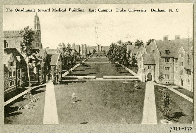 Black and white photograph of a large rectangular green space boxed in by large stone buildings on each side. The green space has paths that cut across it, and trees lining the outer edges.