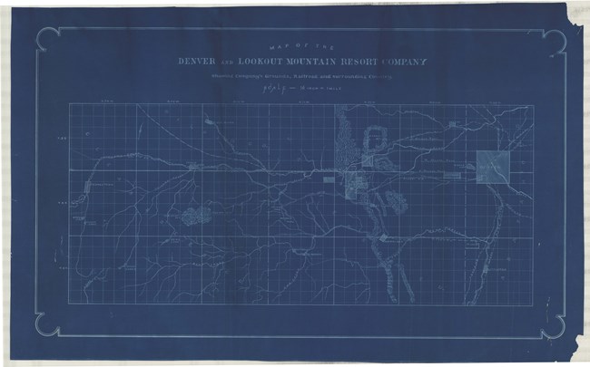 Blue paper with white lines shows large area with some buildings and lines for water.