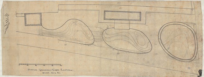 Pencil drawing of two roads with three circular green spaces in the middle and two buildings on the far side of the road.