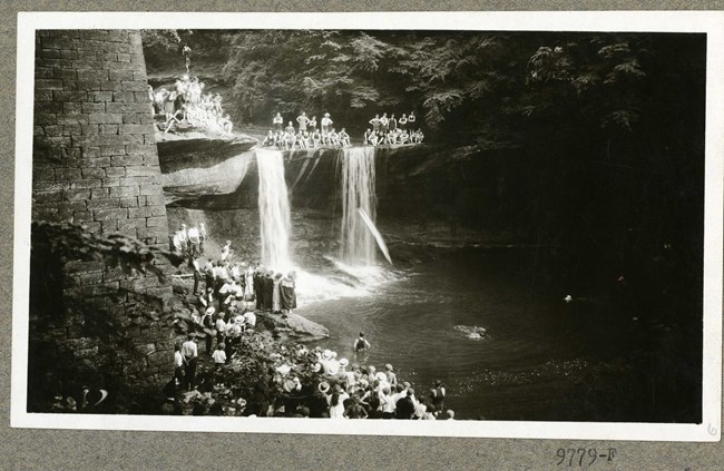 Black and white of creek with people swimming in it and small gorge