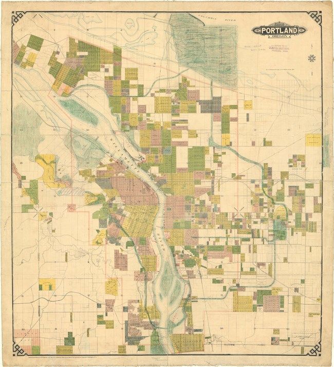 Map of city with river running through it and many grids, some green to show parks.