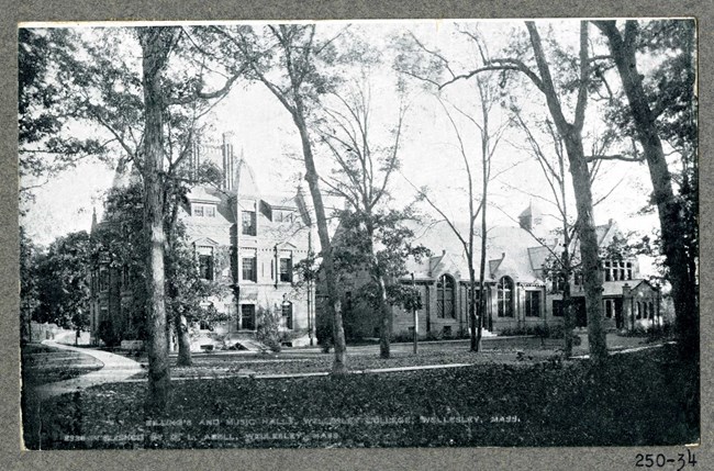 Black and white of large building with trees spaced out and walking paths cutting through grass.