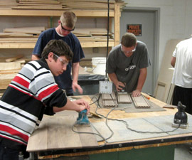 Woodworking students sanding wood