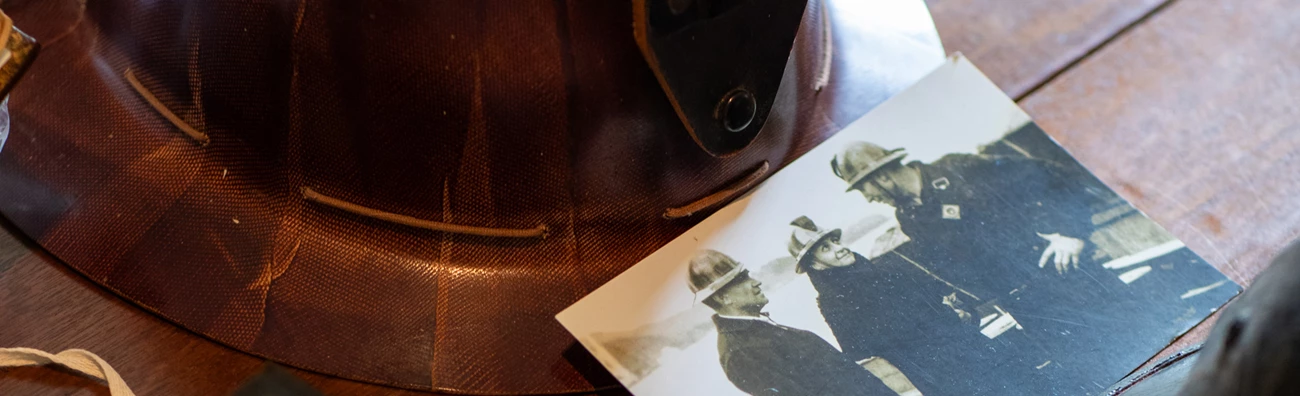 Frances Perkins and group of men wearing safety helments. Frances Perkins and group of men wearing safety helments.