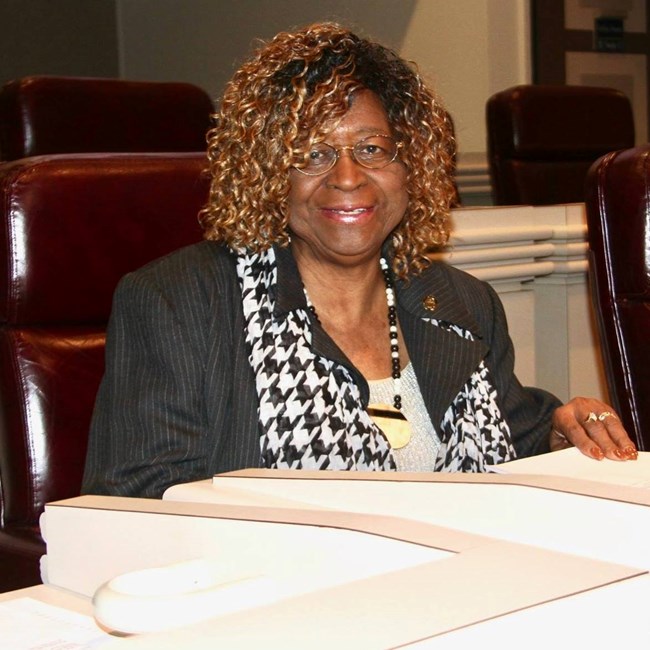 A woman sitting at a desk smiling at the camera
