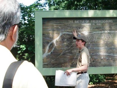 Intern begins guided walking tour beside large battle painting at Fredericksburg Intern begins guided walking tour beside large battle painting at Fredericksburg