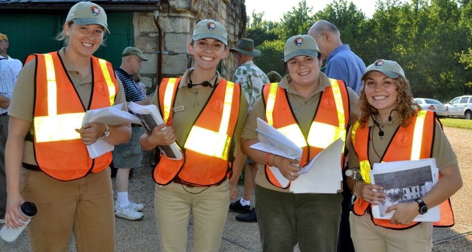 Four interns in orange traffic vests assist with a special program Four interns in orange traffic vests assist with a special program