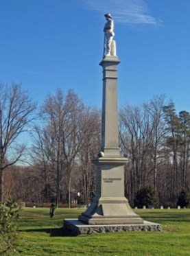 Tall monument in center of Spotsylvania Confederate Cemetery with grass and trees Tall monument in center of Spotsylvania Confederate Cemetery with grass and trees