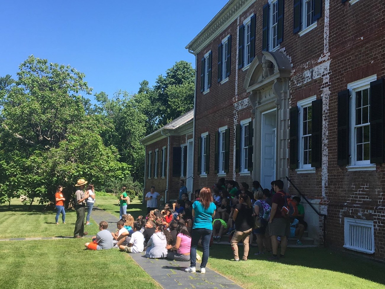 Park Ranger speaks to a class of students in front of Chatham Manor.