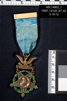 Medal of Honor attached to blue ribbon with ruler shown for scale Medal of Honor attached to blue ribbon with ruler shown for scale