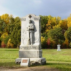 Monument in front of rolling landscape  and treeline with fall foliage