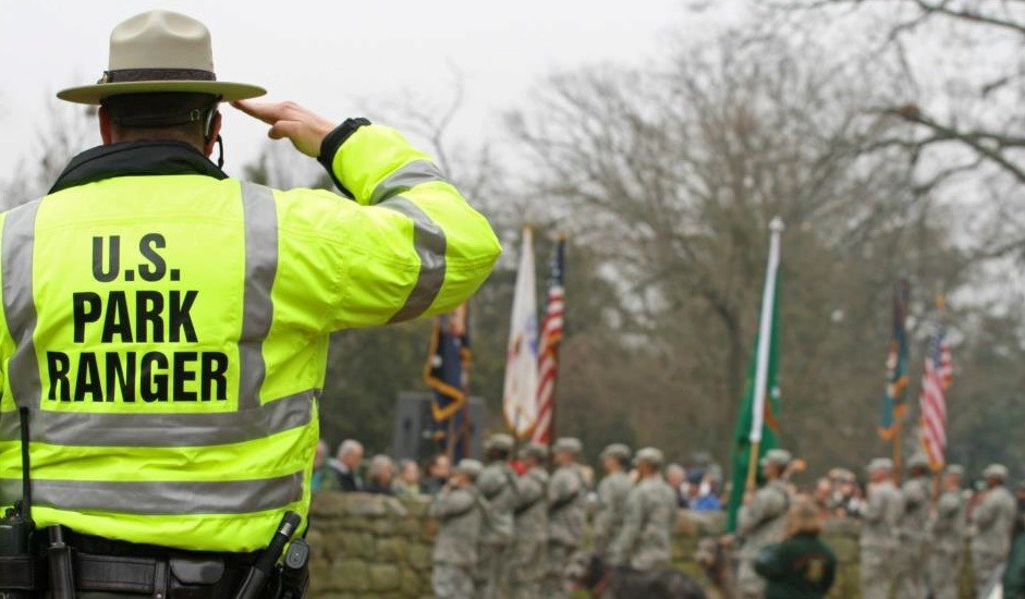 Park law enforcement ranger in yellow best saluting during 150th anniversary commemoration on the Sunken Road Park law enforcement ranger in yellow best saluting during 150th anniversary commemoration on the Sunken Road
