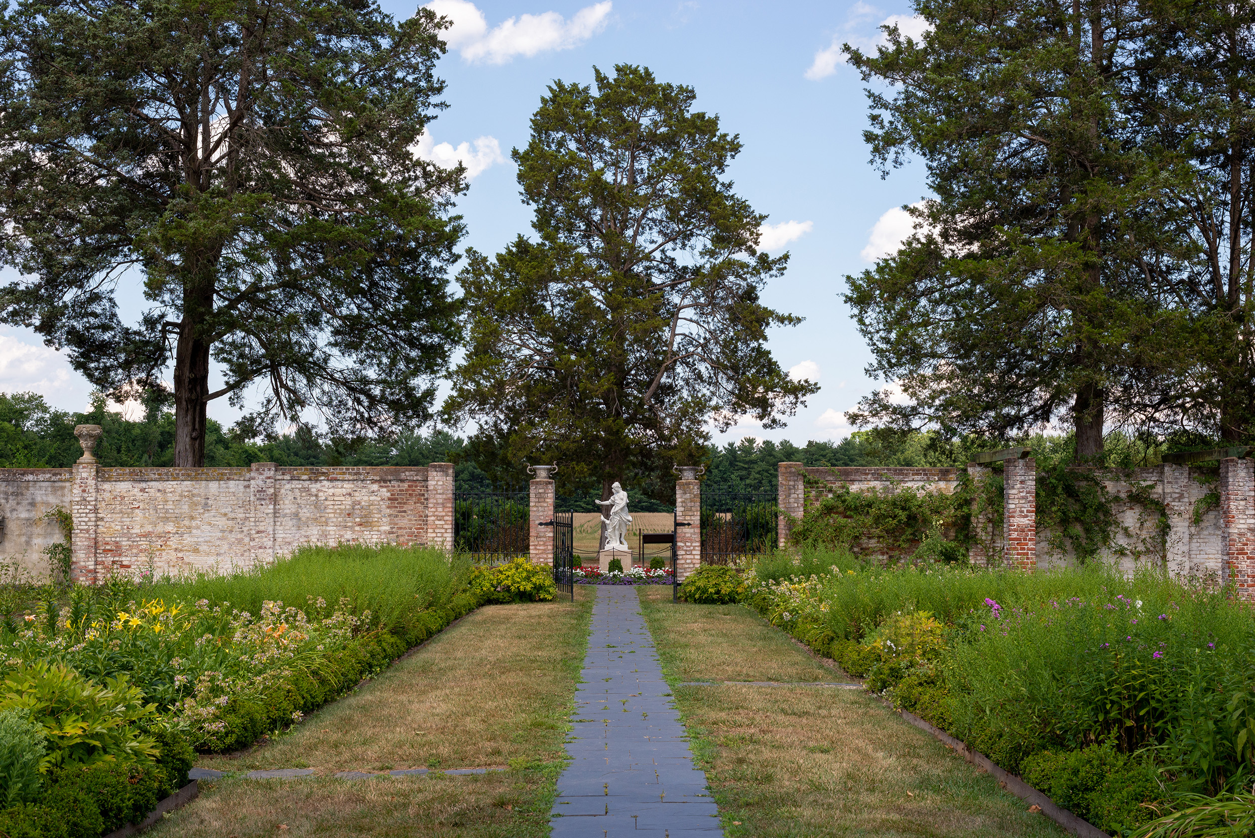 20200713_ChathamGardens_mo_006 copy A path leading to a statue surrounded by gardens.