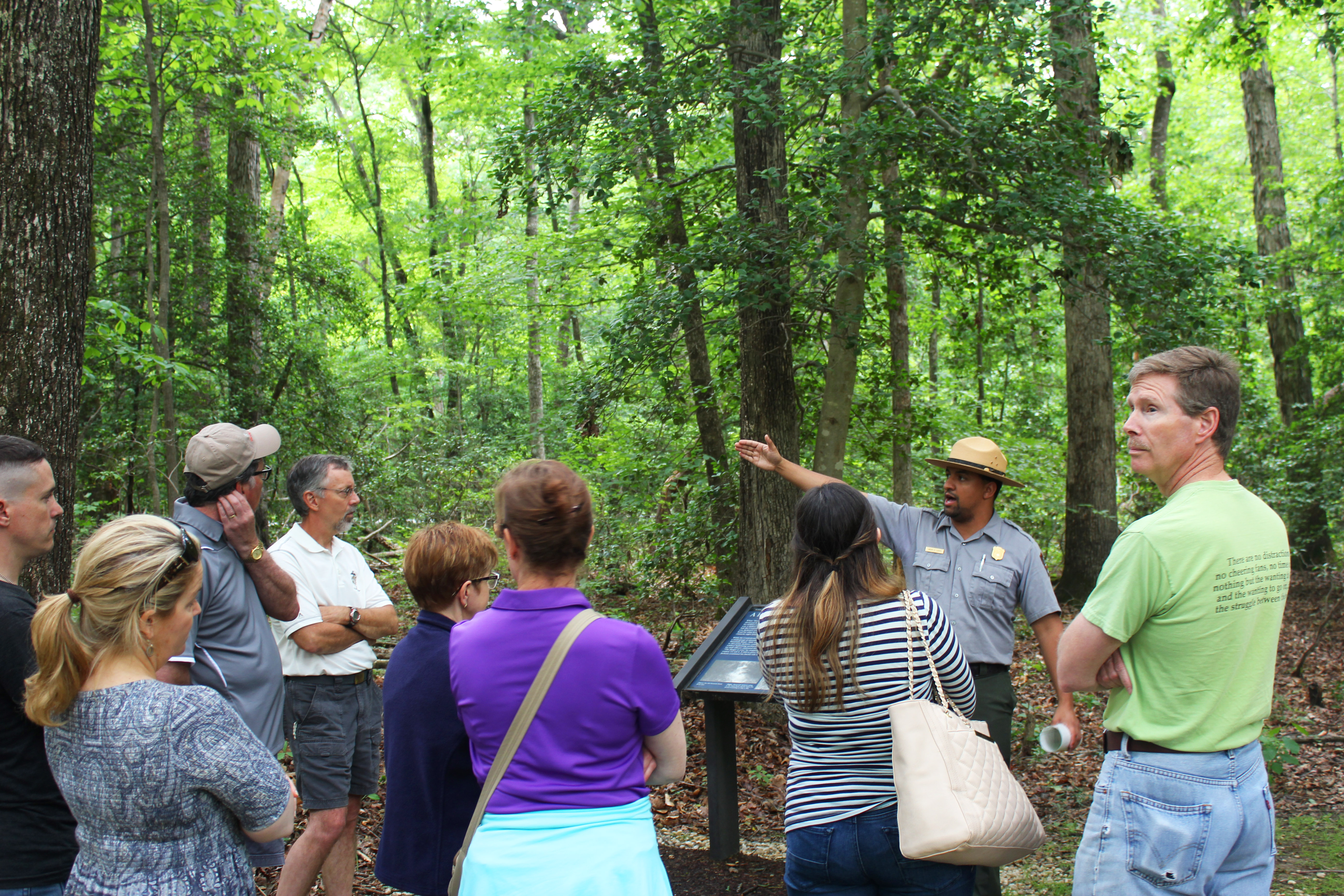 Avery tour at Chancellorsville Crowd listens intently as ranger points in the distance with trees in the background