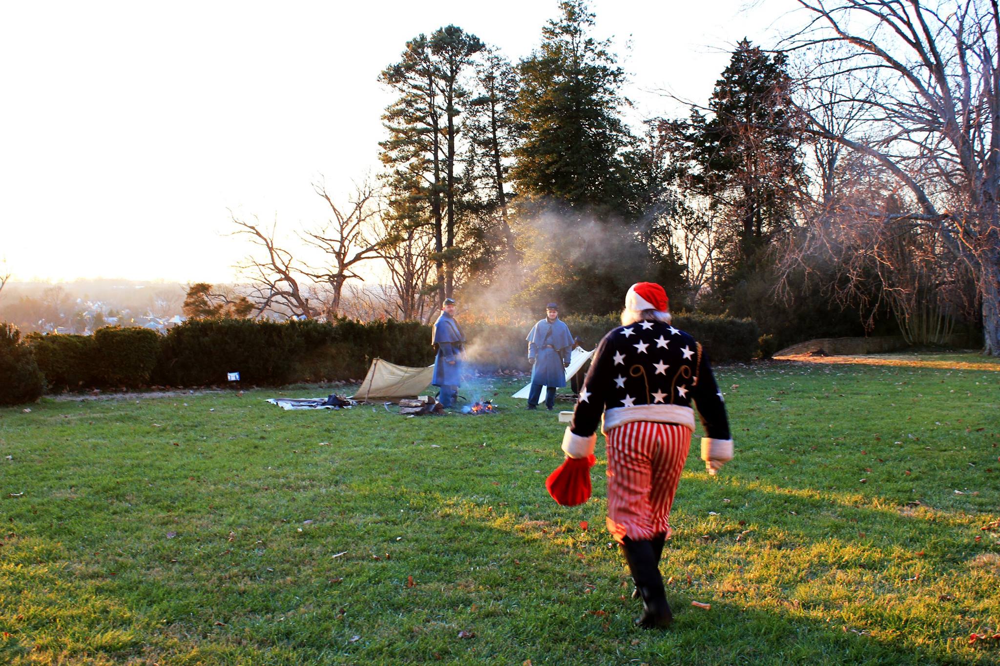Civil War Santa Santa in red, white and blue Civil War era costume walks toward Union soldiers at campfire.
