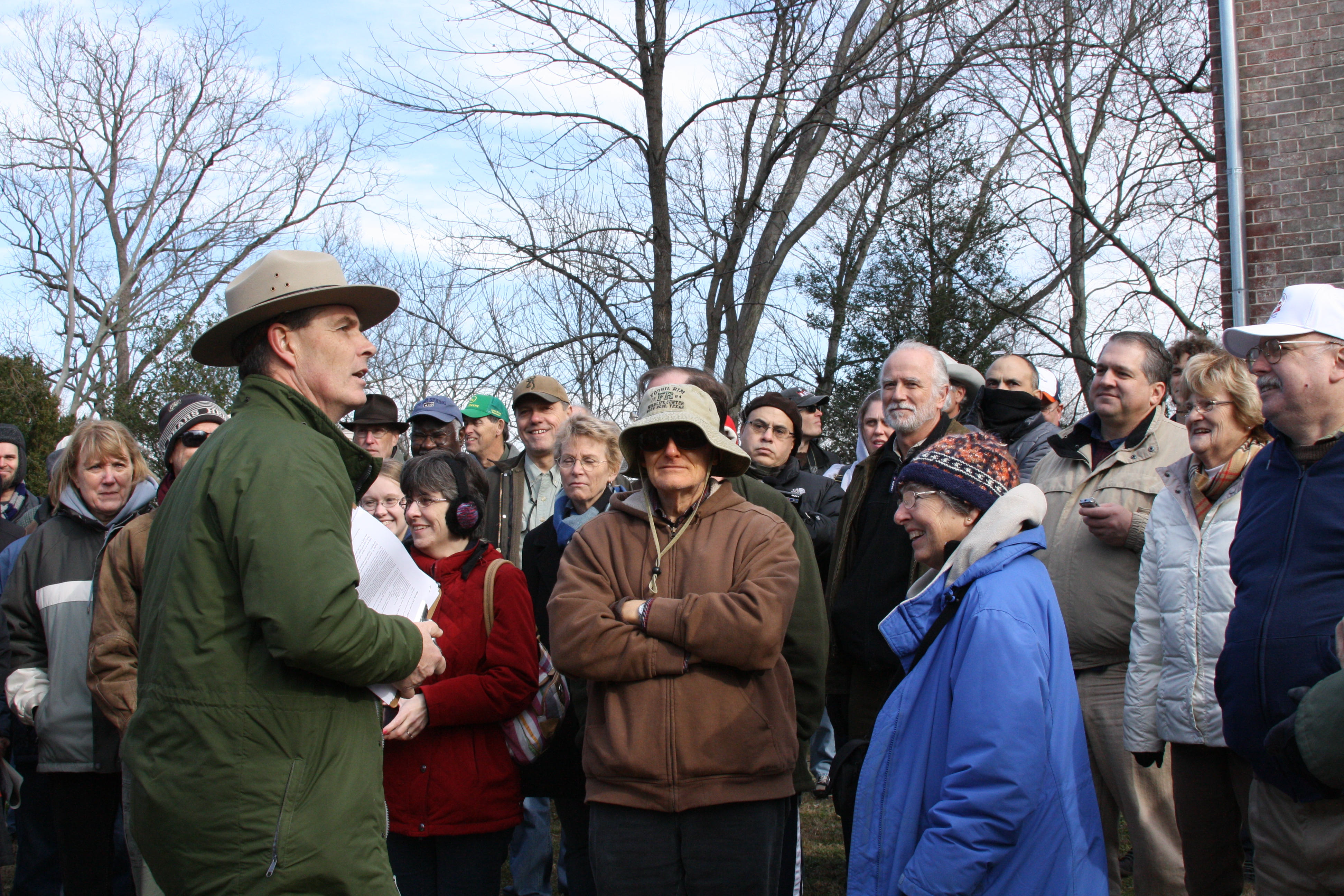 A Park Ranger speaking to a group of people outside.