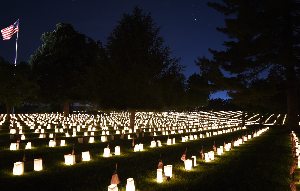 Photo of the 2016 National Cemetery Illumination Photo taken of the Fredericksburg National Cemetery at night with small luminaries on each grave and the U.S. flag in the background