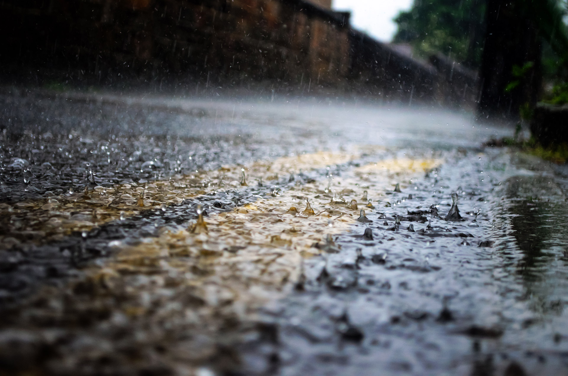 Close-up of road pavement with rain drops falling rapidly