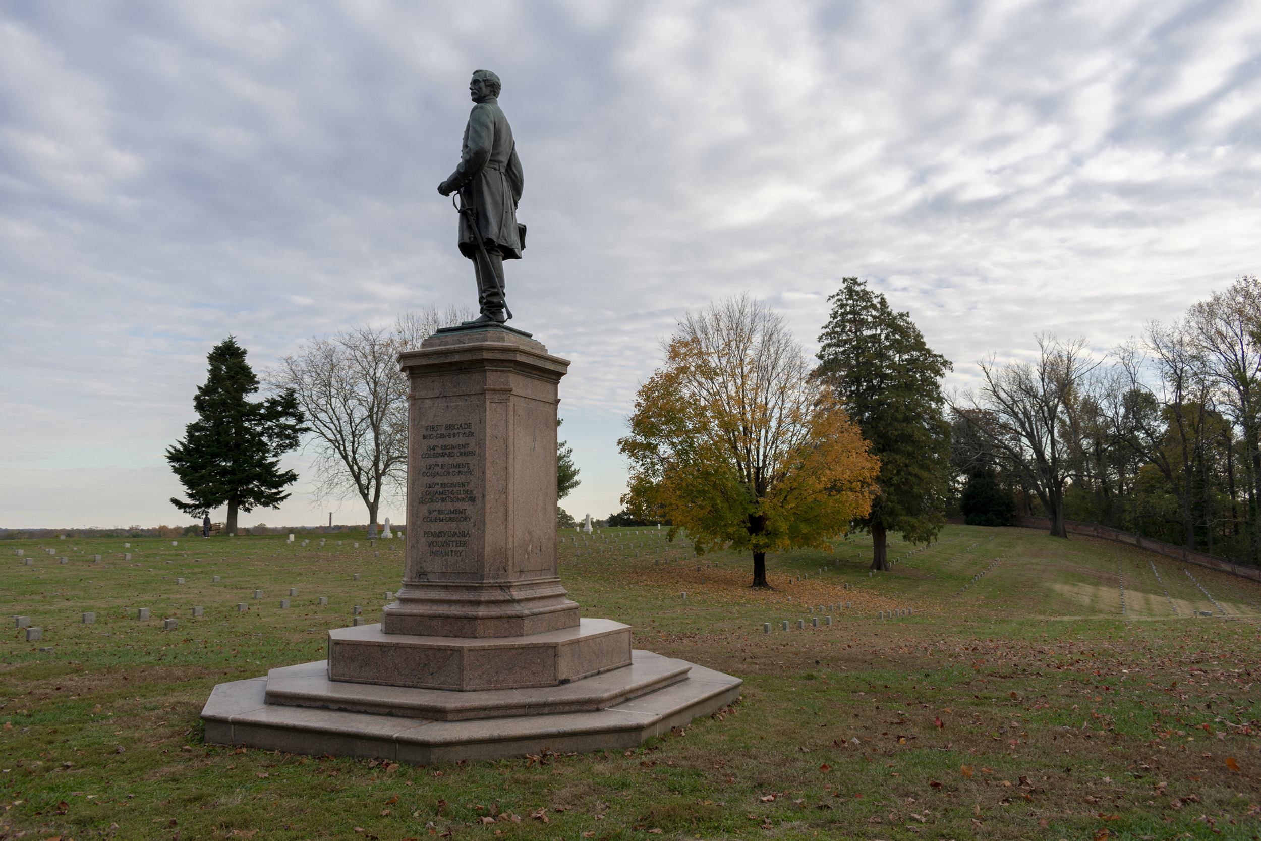 A bronze statue of a Union soldier in a cemetery.