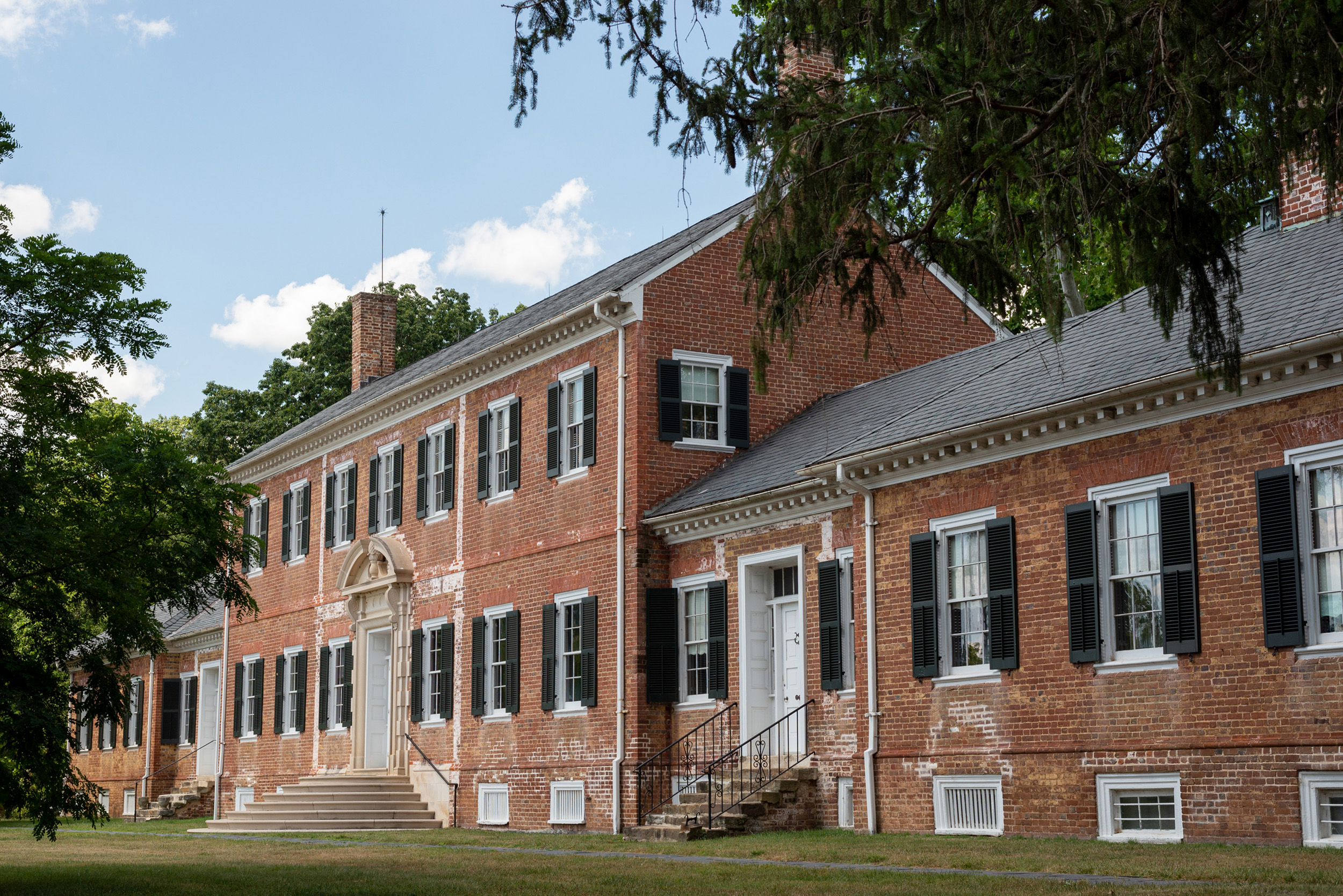 A two story brick mansion with well manicured lawn.