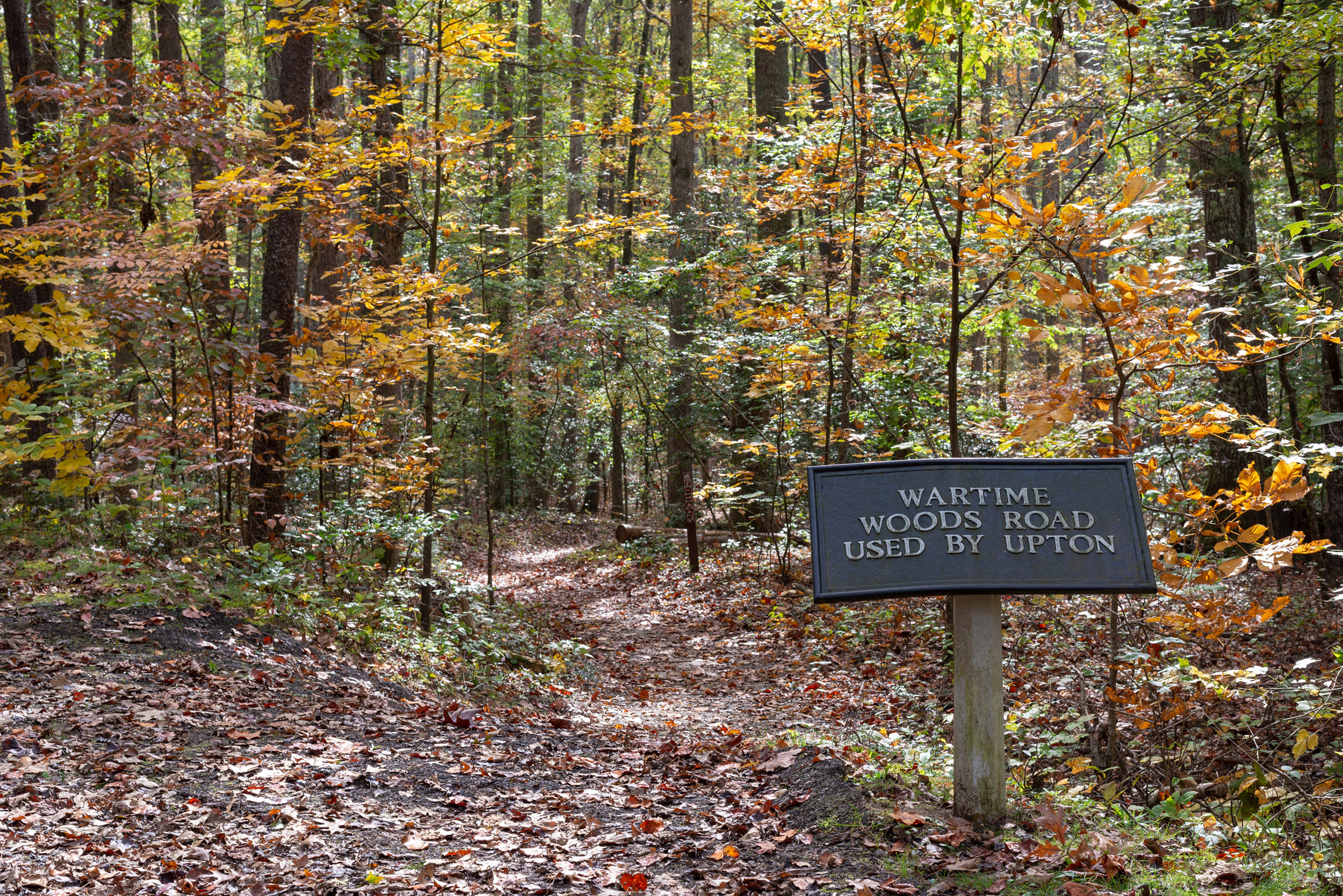 Rectangular metal sign leading to trail through the woods where Upton's soldiers marched.