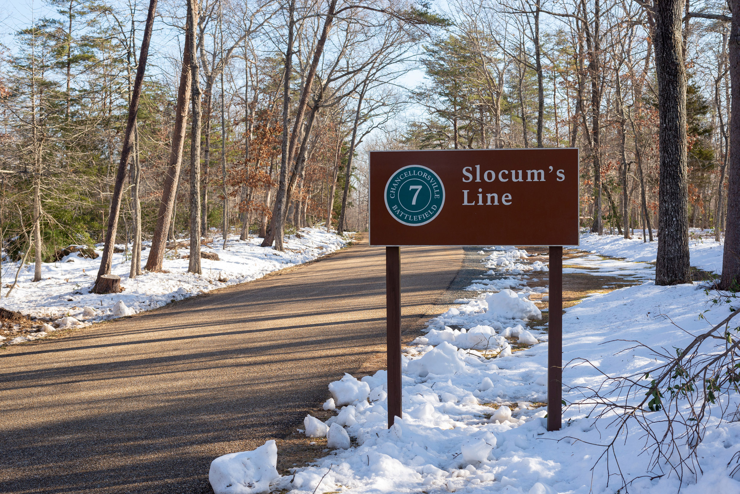 A sign for Slocum's Line next to a road.
