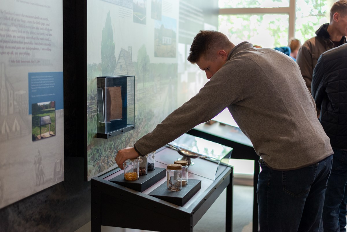 A man looking at an exhibit in indoor visitor center.