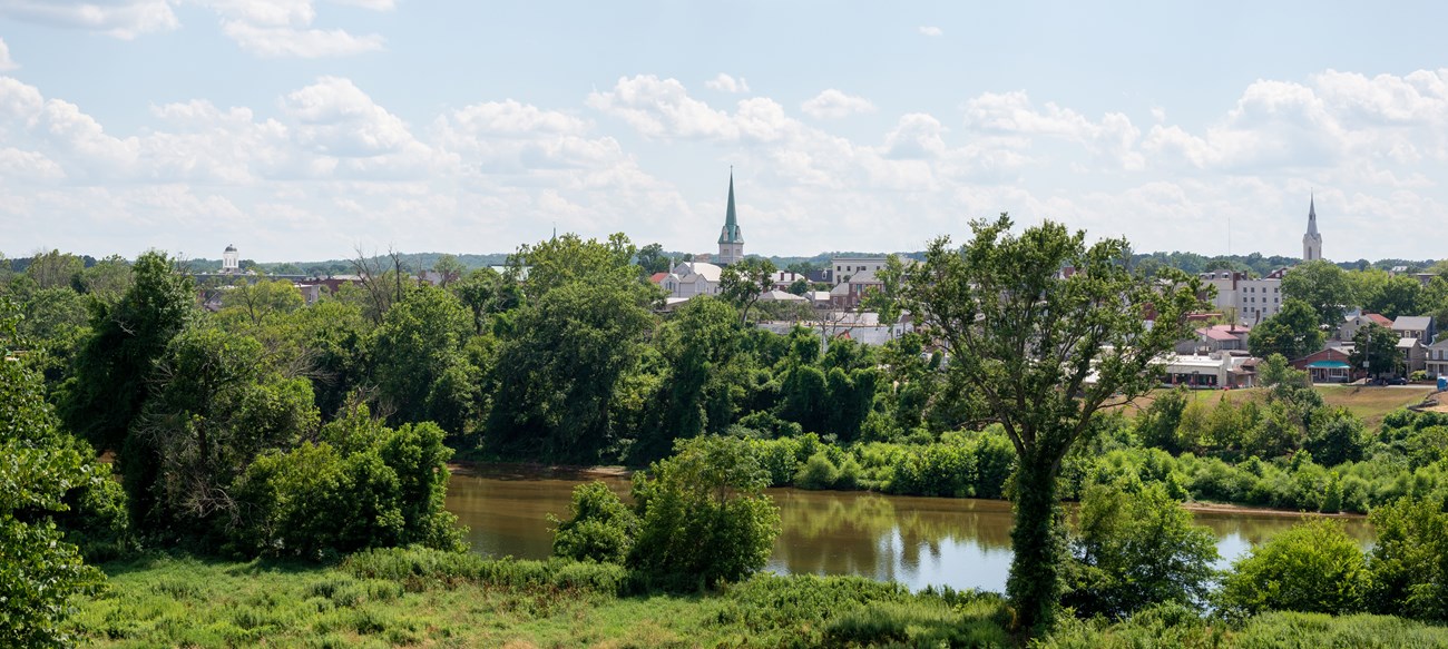 A view of a small city across from a river.