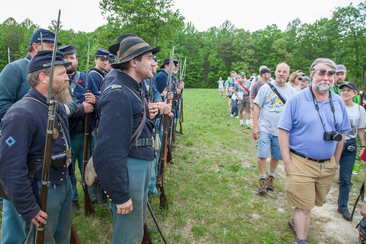 Federals with spectators Photo Credit NPS Federal troop reenactors lined up with visitors walking passed.