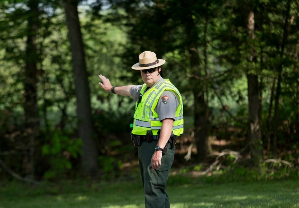 Law enforcement park ranger in yellow vest directs traffic Law enforcement park ranger in yellow vest directs traffic