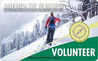 America The Beautiful Volunteer Pass; A man in a red jacket, skiing along a snowy mountainside.