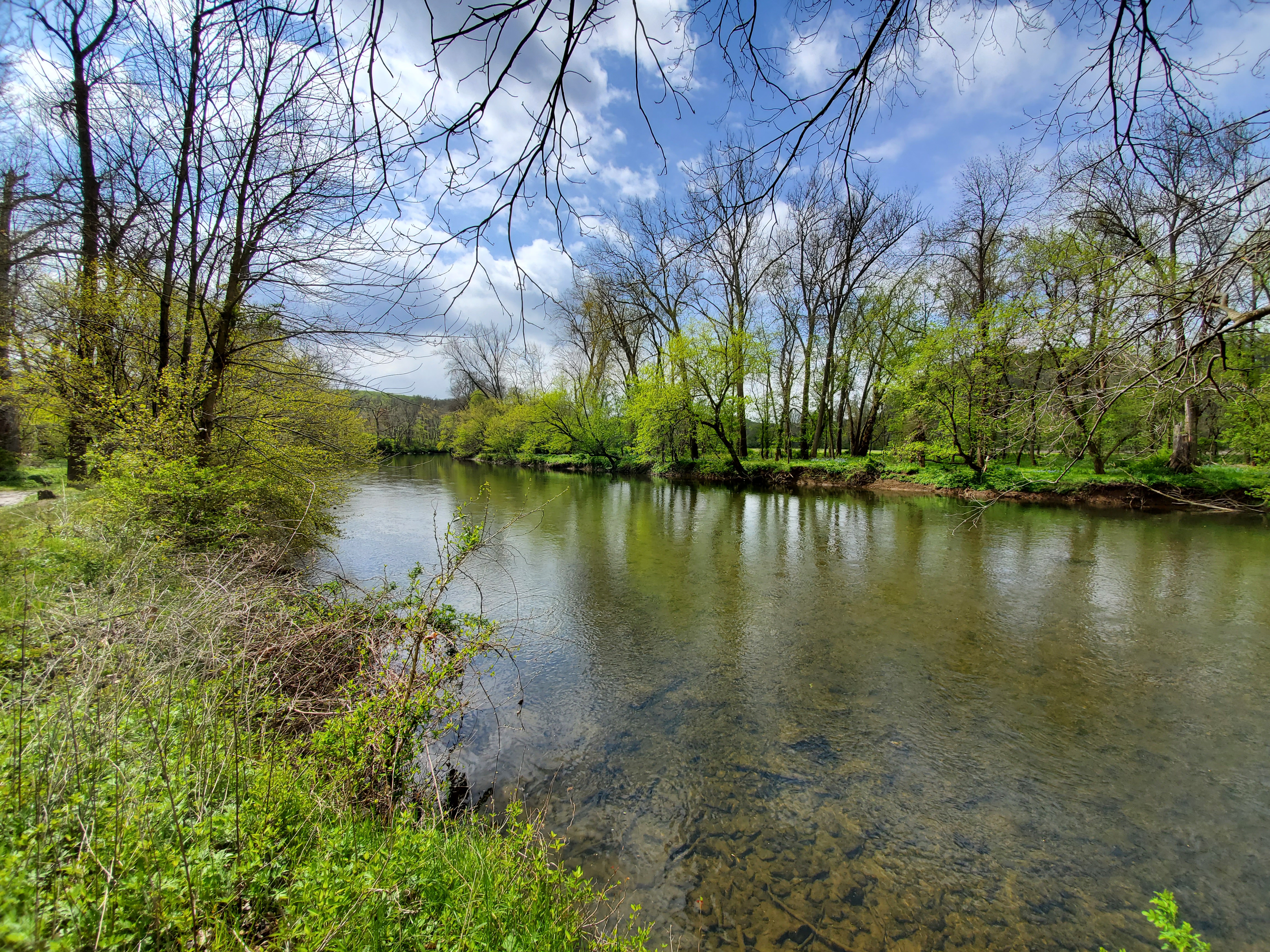 The Brandywine River on a sunny day with clouds in the sky.