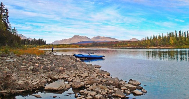 A raft on a river with mountains in the distance A raft on a river with mountains in the distance