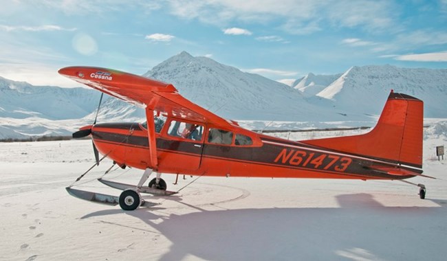 A ski-equipped bushplane on snow in the mountains during winter