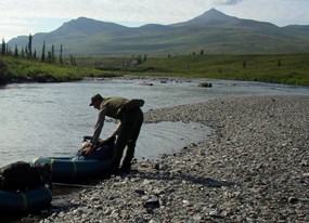Ranger preparing inflatable boat for days float on the Tinyaguk River Ranger preparing inflatable boat for days float on the Tinyaguk River