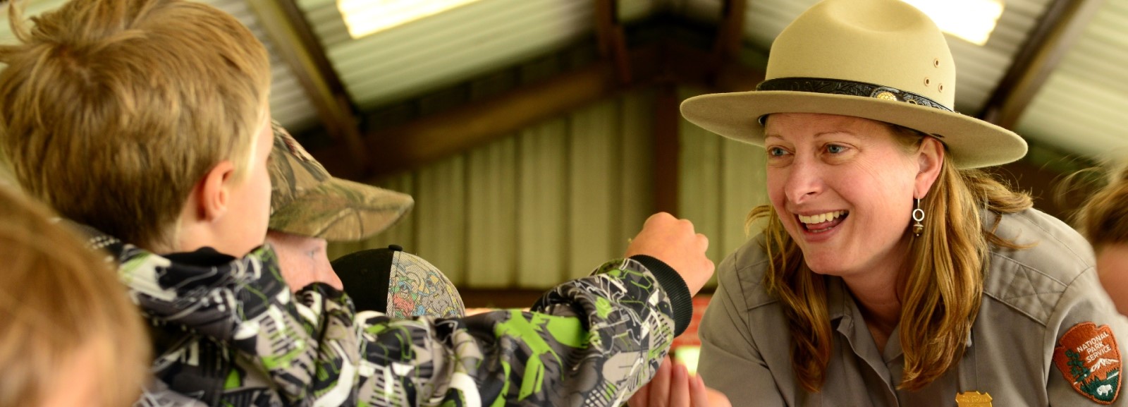 A student holds up work for a park ranger.