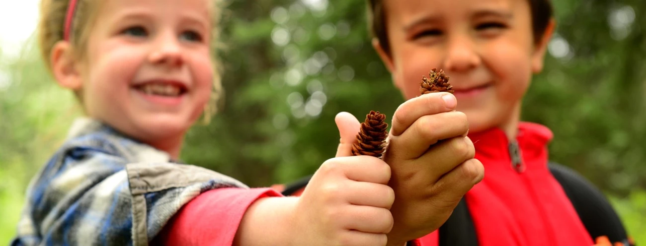 Students with Pinecones Two children hold up pinecones