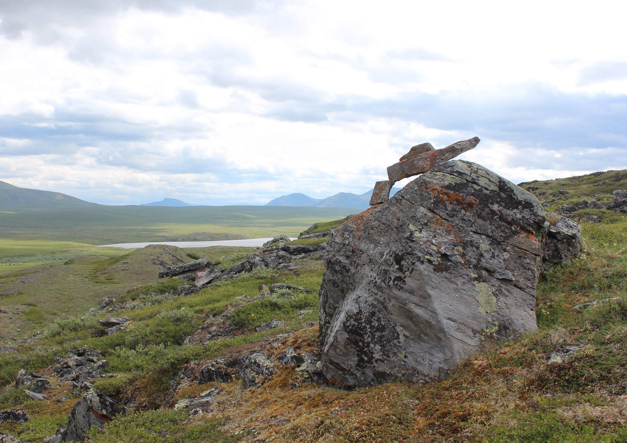 Wide broad rocky valley. Smaller rocks have been built up on a large rock in the foreground